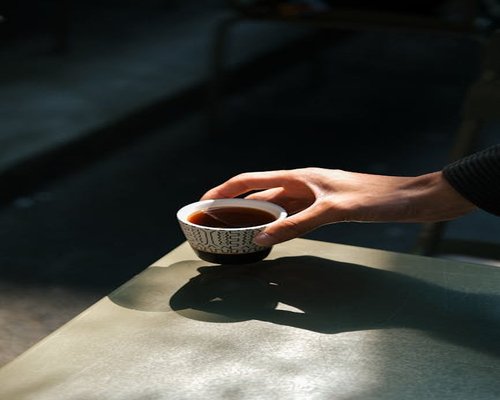 Person holding a warm cup of tea with closed eyes